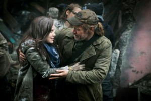 Col. Weaver (Will Patton, R) is thrilled to see his daughter Jeanne (Laci J. Mailey, L) emerge from the rubble. 