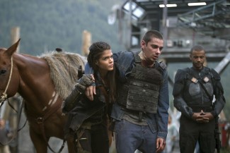 Octavia helps Jasper who nearly got his throat cut...well cut even more...after an altercation with Ice Nation clan. Pictured (L-R) Marie Avgeropoulos as Octavia and Devon Bostick as Jasper 